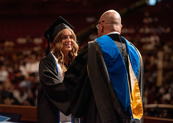 Students partipate in walking to graduate from the College of Business and Communication.
