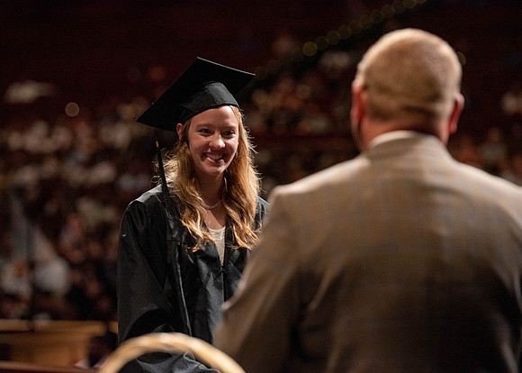Students partipate in walking to graduate from the College of Business and Communication.