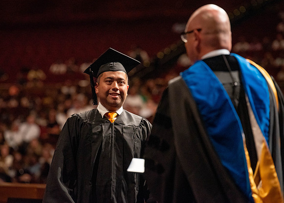 Students partipate in walking to graduate from the College of Business and Communication.