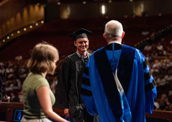 Students partipate in walking to graduate from the College of Business and Communication.