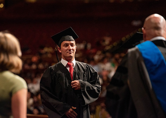 Students partipate in walking to graduate from the College of Business and Communication.