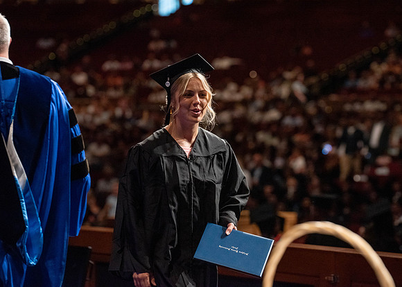Students partipate in walking to graduate from the College of Business and Communication.