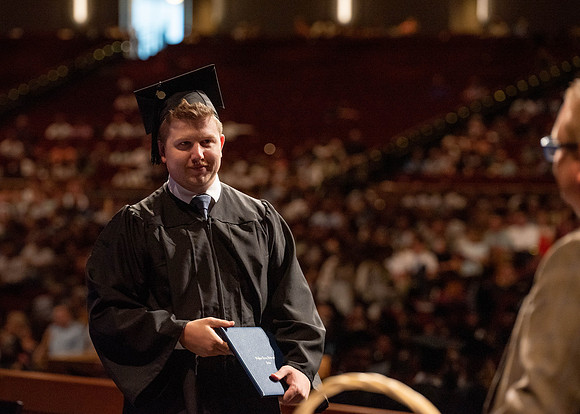 Students partipate in walking to graduate from the College of Business and Communication.