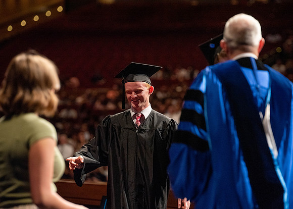 Students partipate in walking to graduate from the College of Business and Communication.