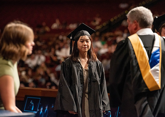 Students partipate in walking to graduate from the College of Business and Communication.