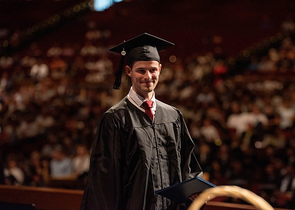 Students partipate in walking to graduate from the College of Business and Communication.