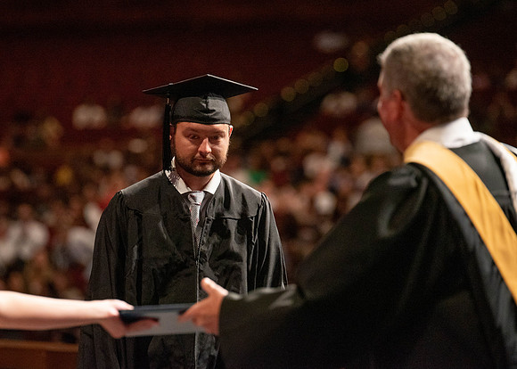 Students partipate in walking to graduate from the College of Business and Communication.
