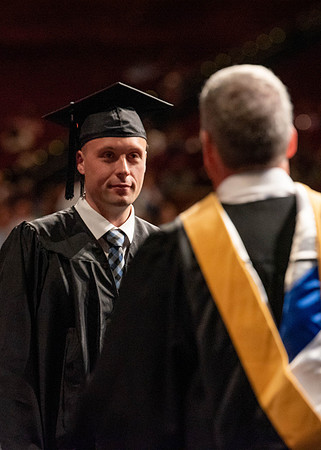 Students partipate in walking to graduate from the College of Business and Communication.