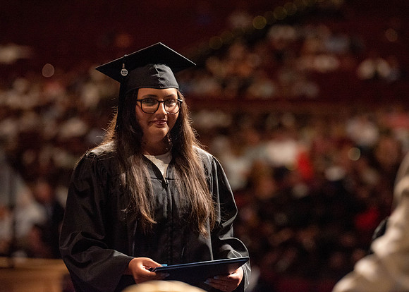 Students partipate in walking to graduate from the College of Business and Communication.