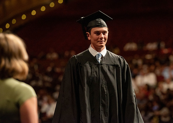 Students partipate in walking to graduate from the College of Business and Communication.