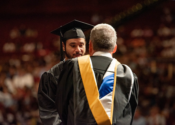 Students partipate in walking to graduate from the College of Business and Communication.