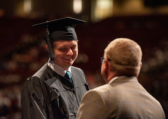 Students partipate in walking to graduate from the College of Business and Communication.