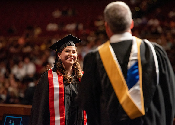 Students partipate in walking to graduate from the College of Business and Communication.