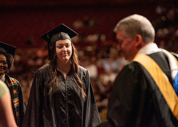 Students partipate in walking to graduate from the College of Business and Communication.