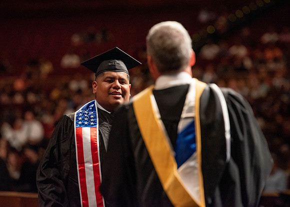 Students partipate in walking to graduate from the College of Business and Communication.