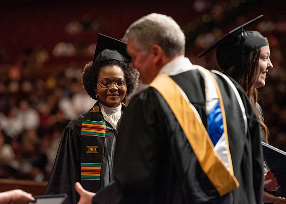 Students partipate in walking to graduate from the College of Business and Communication.