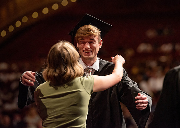 Students partipate in walking to graduate from the College of Business and Communication.