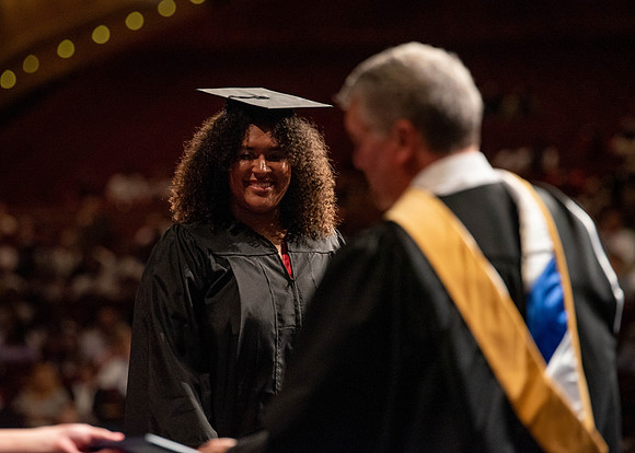 Students partipate in walking to graduate from the College of Business and Communication.
