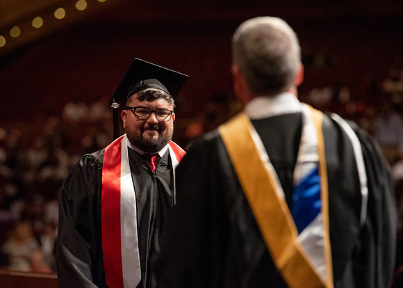 Students partipate in walking to graduate from the College of Business and Communication.
