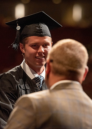Students partipate in walking to graduate from the College of Business and Communication.