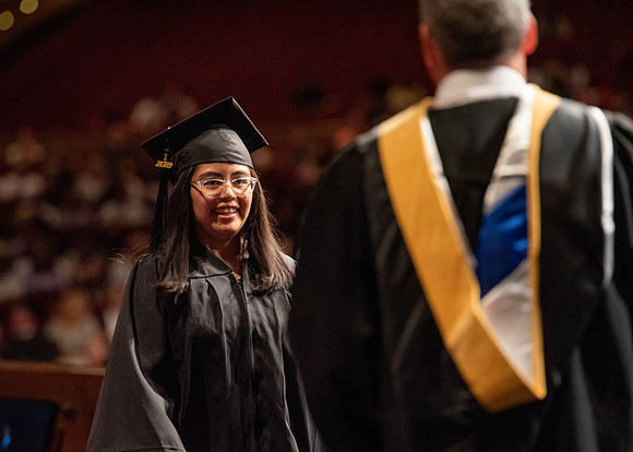 Students partipate in walking to graduate from the College of Business and Communication.