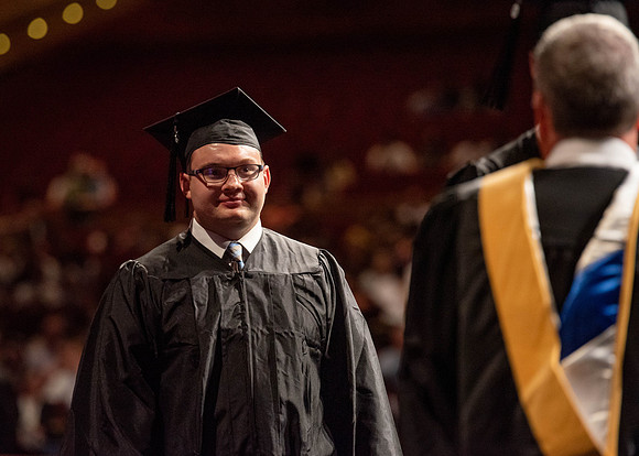 Students partipate in walking to graduate from the College of Business and Communication.