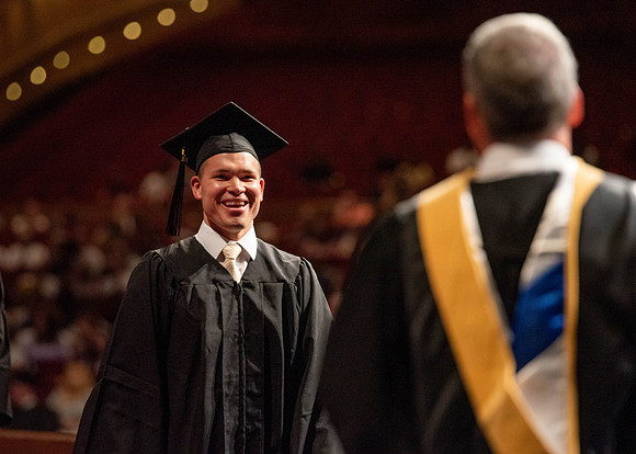 Students partipate in walking to graduate from the College of Business and Communication.