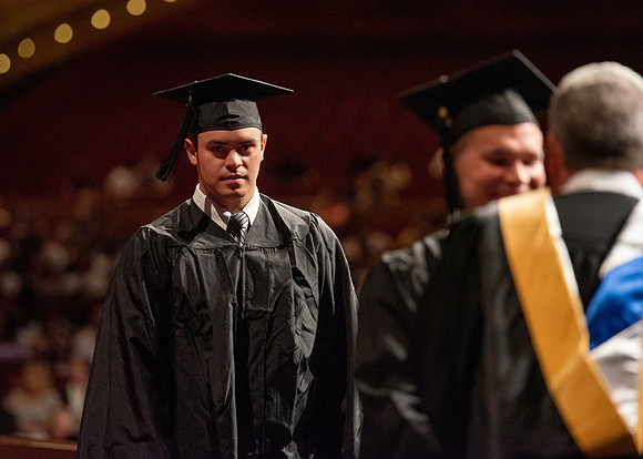 Students partipate in walking to graduate from the College of Business and Communication.
