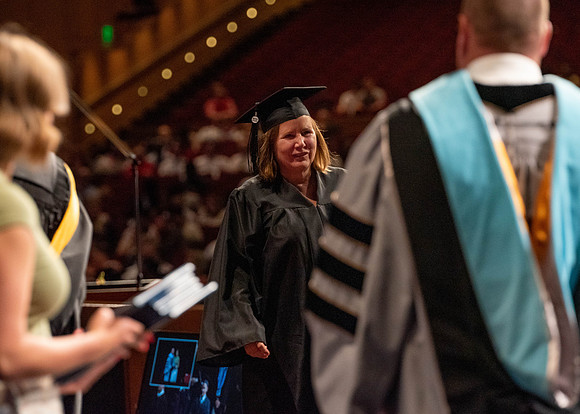 Students partipate in walking to graduate from the College of Business and Communication.