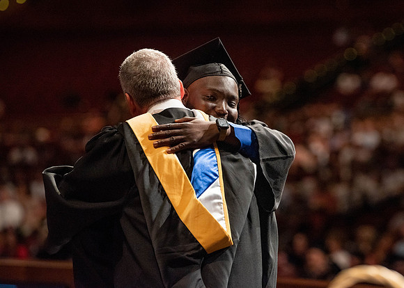 Students partipate in walking to graduate from the College of Business and Communication.