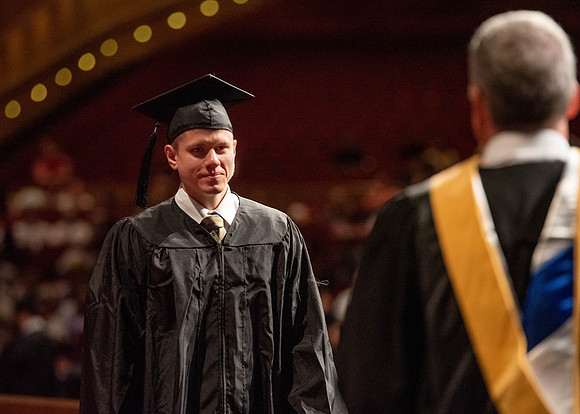 Students partipate in walking to graduate from the College of Business and Communication.