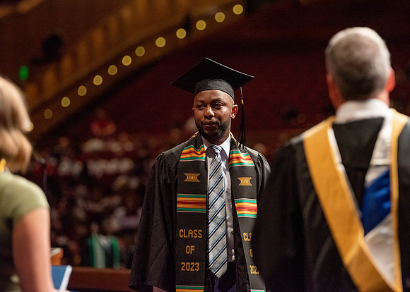 Students partipate in walking to graduate from the College of Business and Communication.