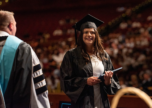 Students partipate in walking to graduate from the College of Business and Communication.