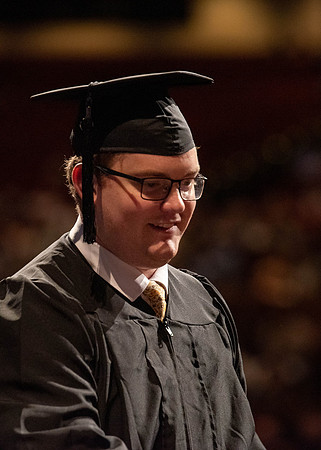 Students partipate in walking to graduate from the College of Business and Communication.