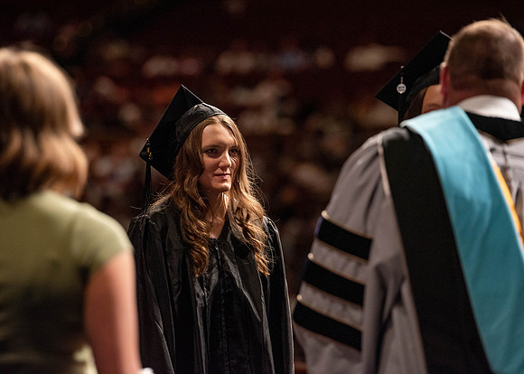 Students partipate in walking to graduate from the College of Business and Communication.