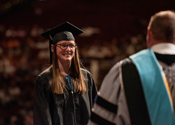 Students partipate in walking to graduate from the College of Business and Communication.
