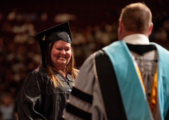 Students partipate in walking to graduate from the College of Business and Communication.