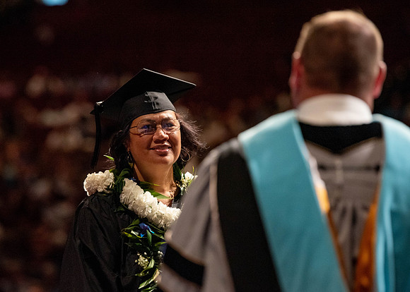 Students partipate in walking to graduate from the College of Business and Communication.