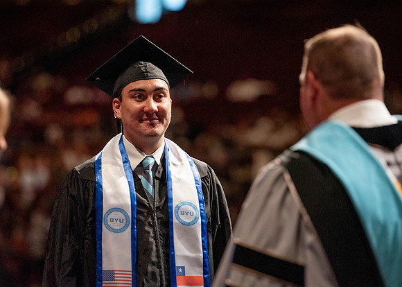 Students partipate in walking to graduate from the College of Business and Communication.