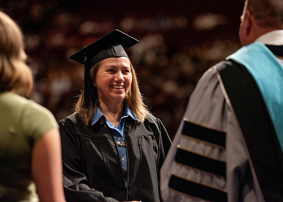 Students partipate in walking to graduate from the College of Business and Communication.