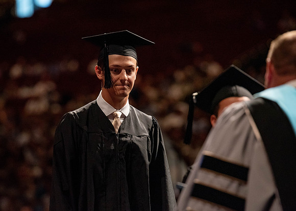 Students partipate in walking to graduate from the College of Business and Communication.