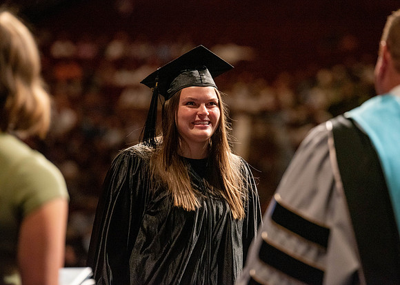 Students partipate in walking to graduate from the College of Business and Communication.