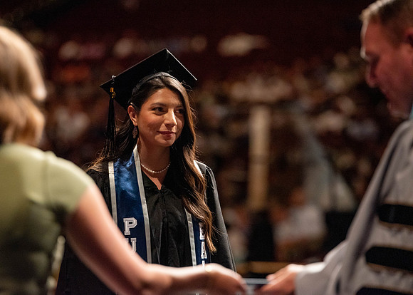 Students partipate in walking to graduate from the College of Business and Communication.