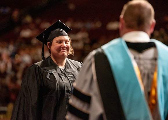 Students partipate in walking to graduate from the College of Business and Communication.