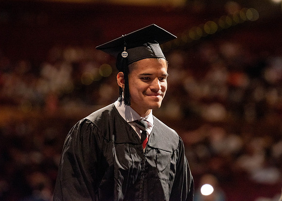 Students partipate in walking to graduate from the College of Business and Communication.