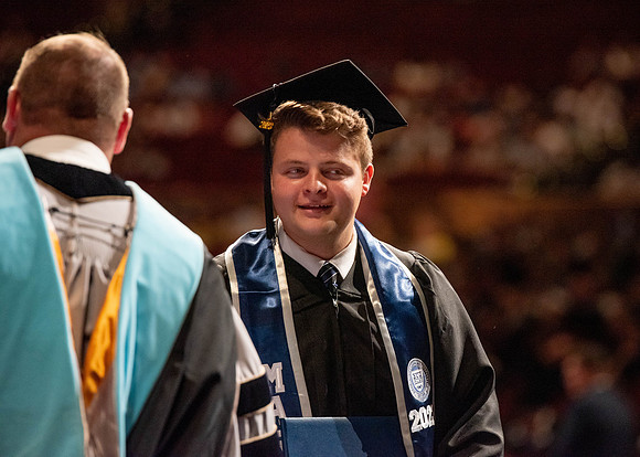 Students partipate in walking to graduate from the College of Business and Communication.