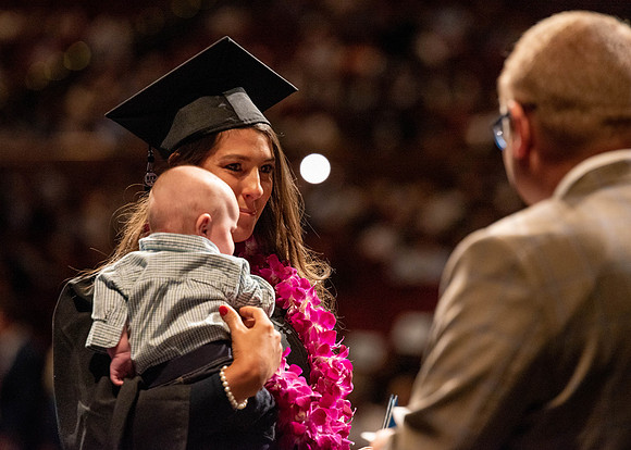 Students partipate in walking to graduate from the College of Business and Communication.