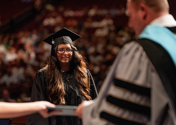 Students partipate in walking to graduate from the College of Business and Communication.