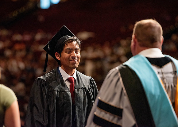 Students partipate in walking to graduate from the College of Business and Communication.