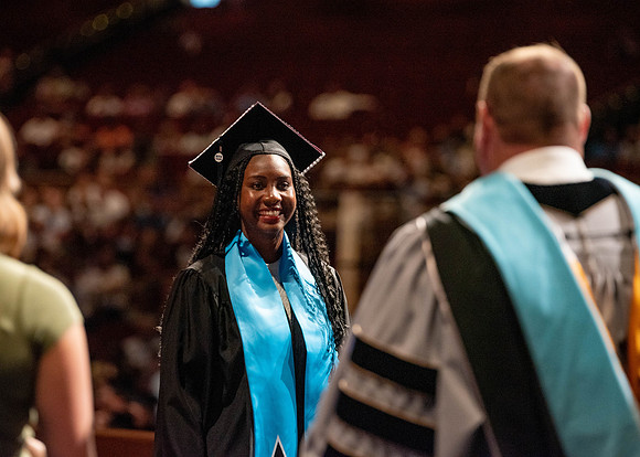 Students partipate in walking to graduate from the College of Business and Communication.